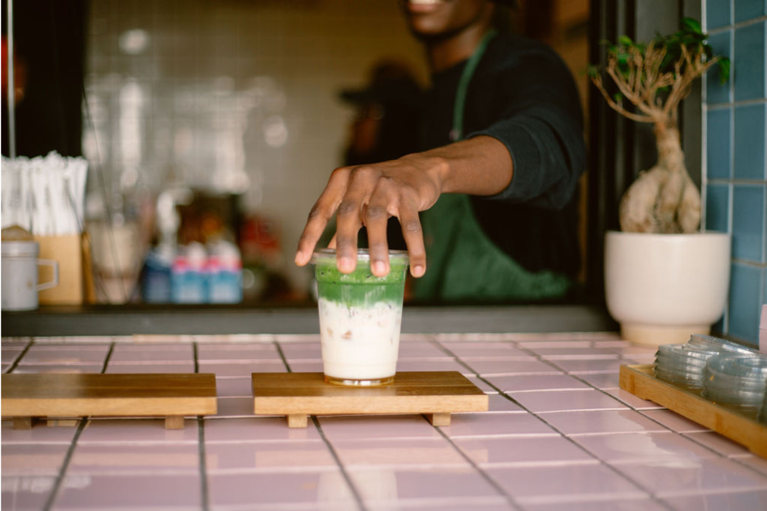 Nice To Matcha barista serving an iced matcha latte at the Sea Point bar
